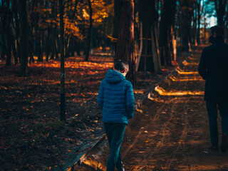 Boy in a blue jacket walking in forest