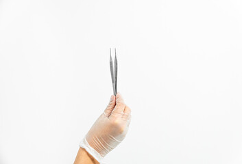 Close-up of a podiatrist's hand with gloves holding tweezers on a white background