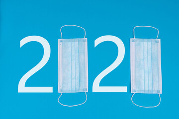 2020 logo made from medical masks. As a symbol of a pandemic. Blue background.