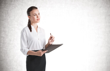 Thoughtful young businesswoman with folder