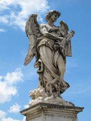 Fototapeta na wymiar A statue of a winged angel on Saint Angel bridge in Rome, Italy, which is also known as Ponte Sant'Angelo. Image has copy space.