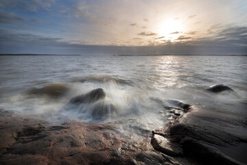 Sea landscape. Sunset in Finland coast rocks and waves.