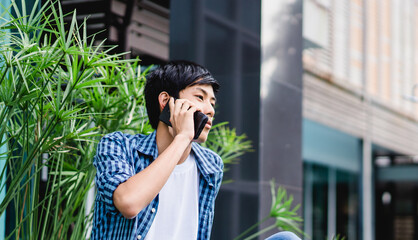 Young asian handsome pre teen boy smiling calling with smartphone at home.Portrait of asian teenager man with smart phone talking with mentor.Technology 5g communication.Stay at home.Stay safe.covid19