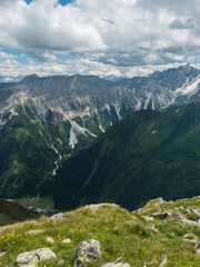 view from Pramarnspitze saddle on Gschnitztal Valley and snow-capped moutain panorama at Stubai hiking trail, Stubai Hohenweg, Alpine landscape of Tyrol Alps, Austria. Summer blue sky, white clouds