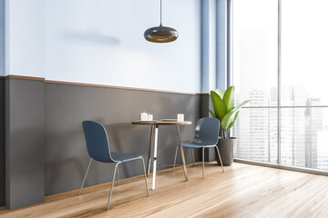 Blue and black cafe, two chairs with table with plant near window