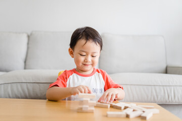Naklejka premium 3 years old boy.toddler child playing with lots of wooden toys block with mother.Kids play with education toy at home.Day care and Kindergaten school.child development concept.Ef, Home school kid.