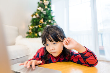 Asian kids sibling sister brother video call in christmas holidays celebrate at home.Online video call zoom.Kids watching video with laptop.New normal.Covid-19 coronavirus.Social distancing.stay home.