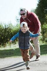 Obraz premium Cute boy and his father have fun outside.