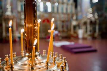 tall candles burn inside the orthodox church