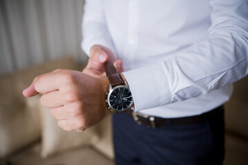 a man puts a classic watch on his hand
