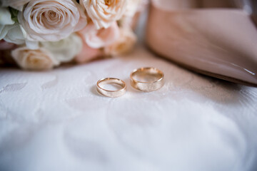 bride shoes with wedding gold rings and bouquet