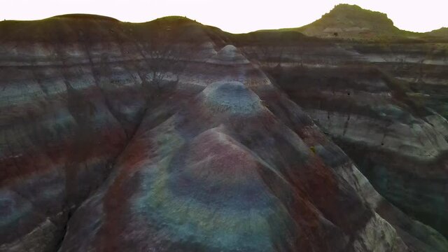 Cinematic aerial flyover of colorful sandstone strata at sunset in Southern  Utah