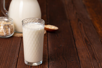Glass pitcher of milk on old wooden table