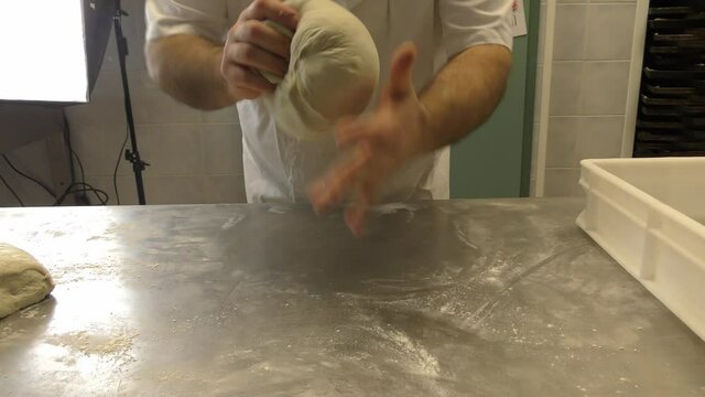 Laboratorio di una panetteria con fornaio che prepara il pane in maniera artigianale