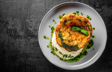 schnitzel with mashed potatoes and pesto sauce on plate