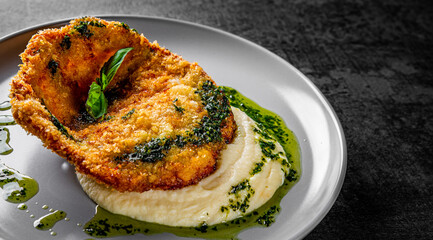 schnitzel with mashed potatoes and pesto sauce on plate