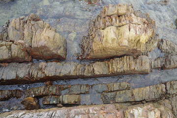 The sandstone on the beach is eroded by the sea and the wind.
