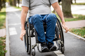 Handicapped man in wheelchair walk at the park alley