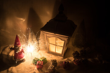 New Year's still-life postcard lamp covered in snow with glowing candle at night.