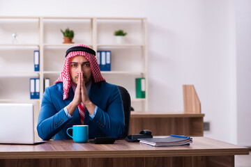 Young male arab employee working in office