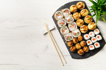 Sushi rolls set on a stone Board for sushi on a light background