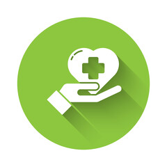White Heart with a cross icon isolated with long shadow. First aid. Healthcare, medical and pharmacy sign. Green circle button. Vector Illustration.
