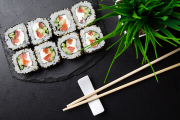 Sushi rolls with sesame seeds on a stone Board for sushi