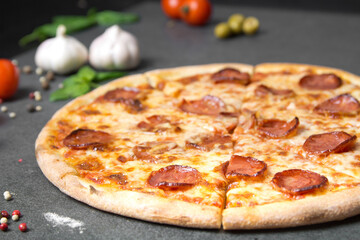 Pizza and ingredients in the background