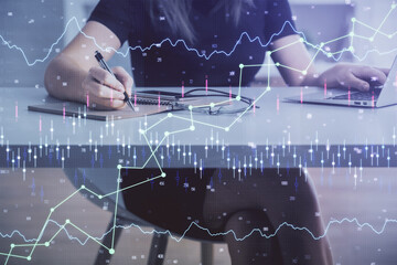 Double exposure of businesswoman hands typing on computer and forex chart hologram drawing. Financial analysis concept.