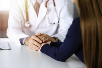 Unknown man-doctor reassuring his female patient, close-up. Perfect medical service, empathy in medicine during Coronavirus pandemic