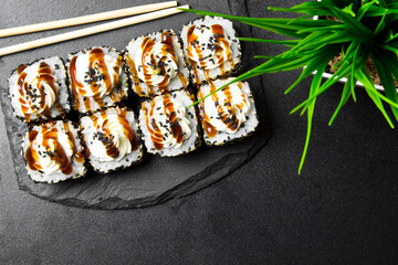 Sushi rolls with sesame seeds and topped with cream cheese
