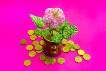 Cash flow concept. Blooming Money tree with benefits, dropped money coins on pink background. Copy space