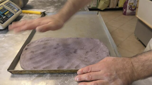 Laboratorio di una panetteria con fornaio che prepara il pane in maniera artigianale