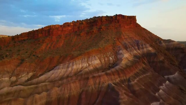 Cinematic aerial flyover of colorful sandstone strata at sunset in Southern  Utah