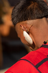 An Abstract Portrait of a young Naga tribesman dressed in his tribal attire wearing a big white earing at Kisama Nagaland India © Sandeep