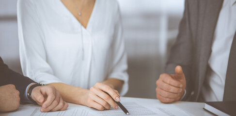 Elderly businessman and group of business people discussing contract in office. Woman and lawyers working together at meeting. Teamwork and cooperation