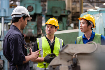 Group of male manufacturing workers working in the industry factory. Male supervisor discussing to...