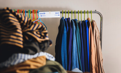 Donation Concept. Separated Used Old Clothes from Wardrobe Rack to Keep and Donate. Focus on Text