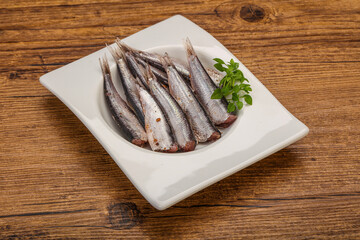 Anchovies in the bowl served basil leaves