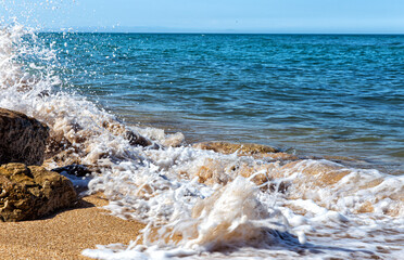 Fototapeta na wymiar Foamy surf on a sandy tropical beach