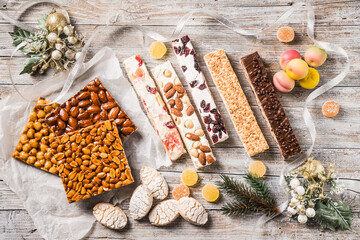 Italian Christmas sweets as different nougats with almonds, nuts, peanuts, candied fruits, marzipan. Traditional Italian Christmas sweets background.
