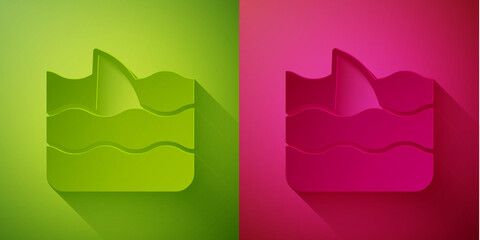 Paper cut Shark fin in ocean wave icon isolated on green and pink background. Paper art style. Vector.