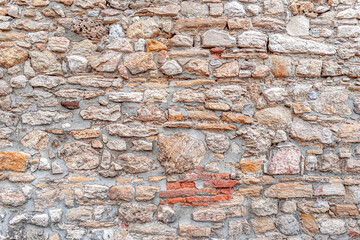 Wall from old gray bricks and stone as an abstract background.