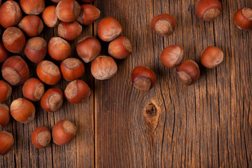 Hazelnut harvest. Lots of hazelnuts on a wooden background in rustic style. Hazelnuts scattered on the table.