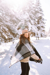Young woman  enjoying winter weather in the snow forest.  Cold weather. Winter fashion, holidays, rest, travel concept.