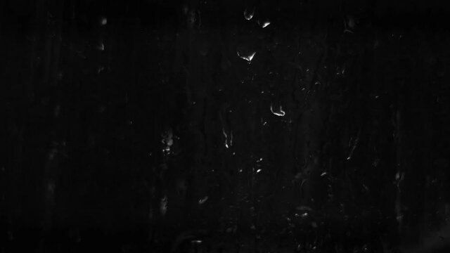 Background with raindrops on a black background for overlay to create mood. Light water on glass isolated on a dark background.