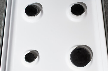 Clean white surface of a gas stove, top view. Gas panel after cleaning