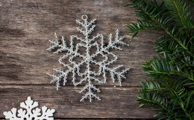 big beaden nowflake on wooden table with yew branch 