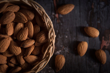almond in basket on dark wooden table