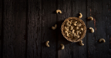 Obraz na płótnie Canvas cashew nuts in basket on dark wooden table